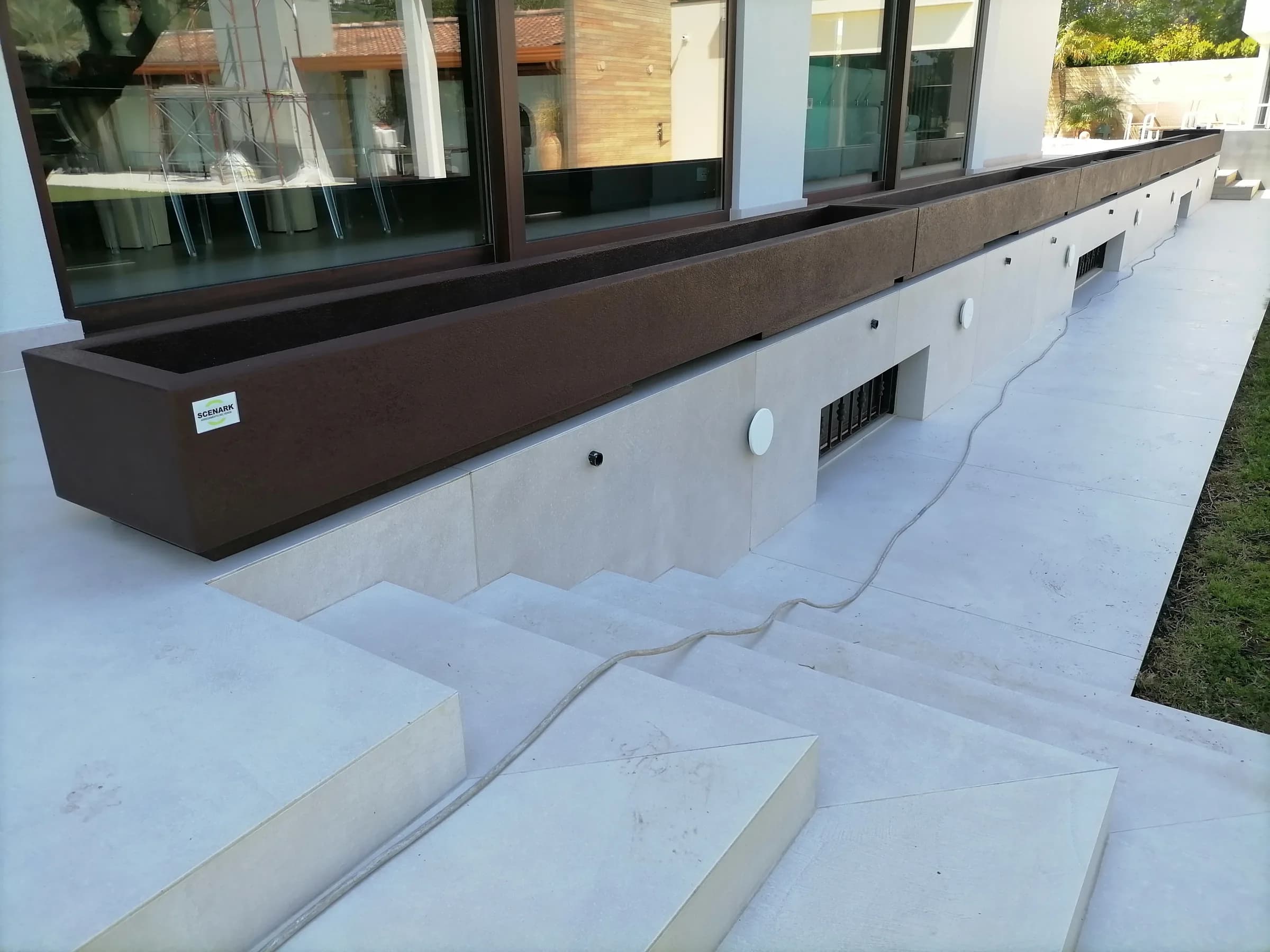 Fioriera parapetto color corten lungo una scala esterna