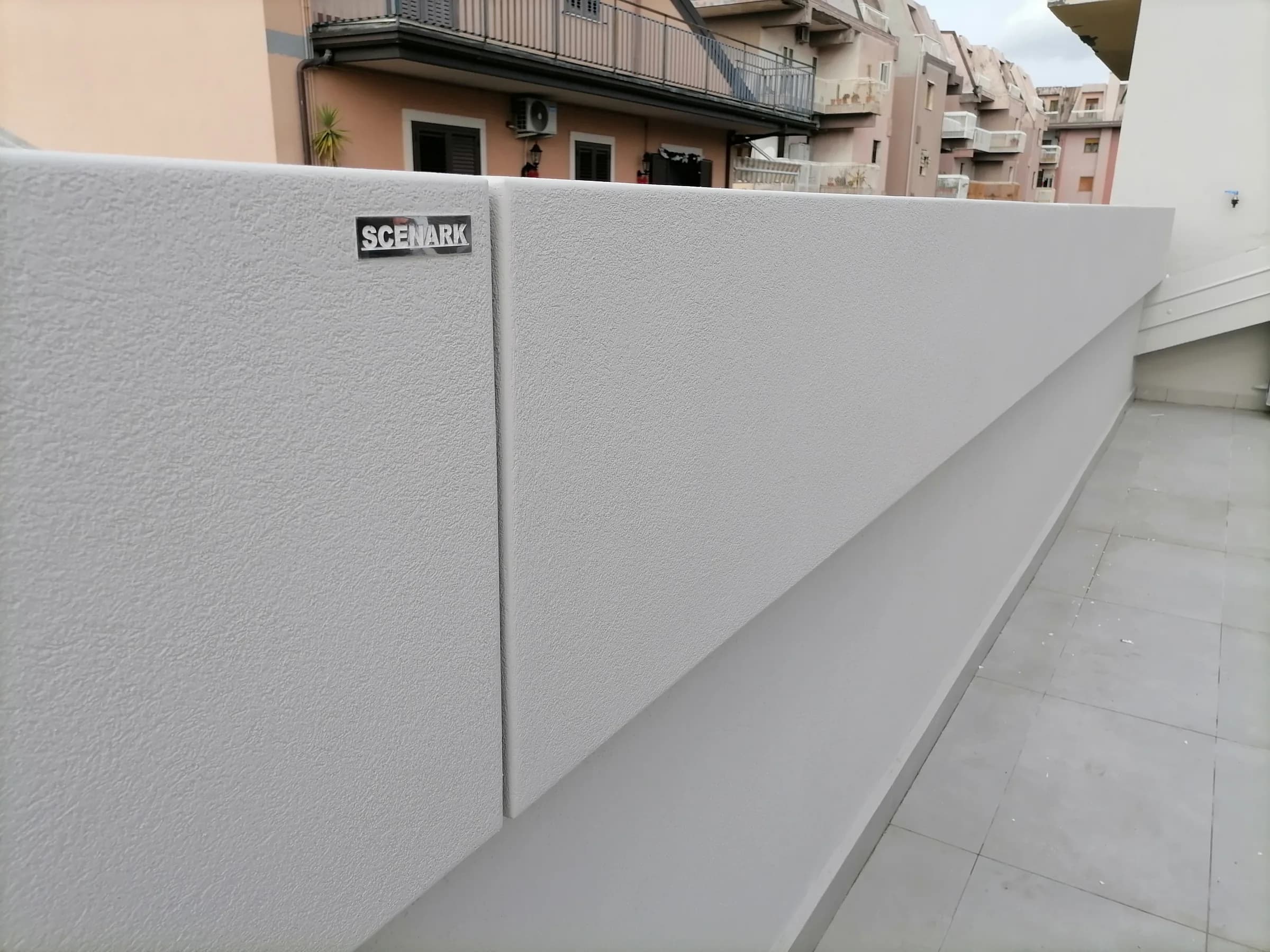 Dettaglio di una fioriera parapetto chiara con il logo Scenark